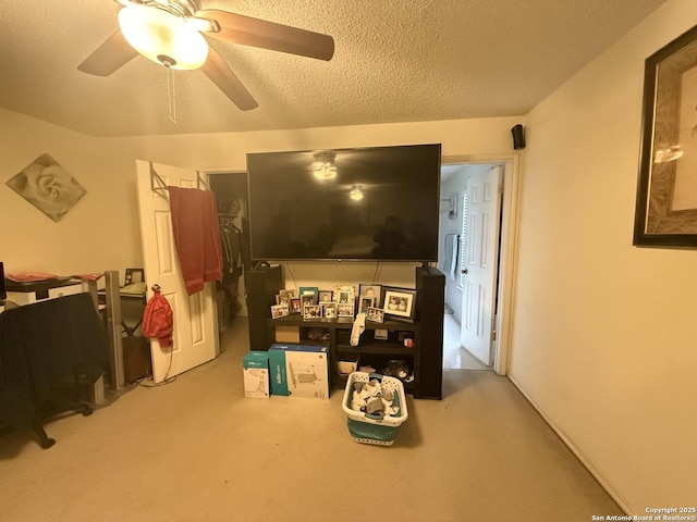 interior space featuring ceiling fan, light colored carpet, and a textured ceiling