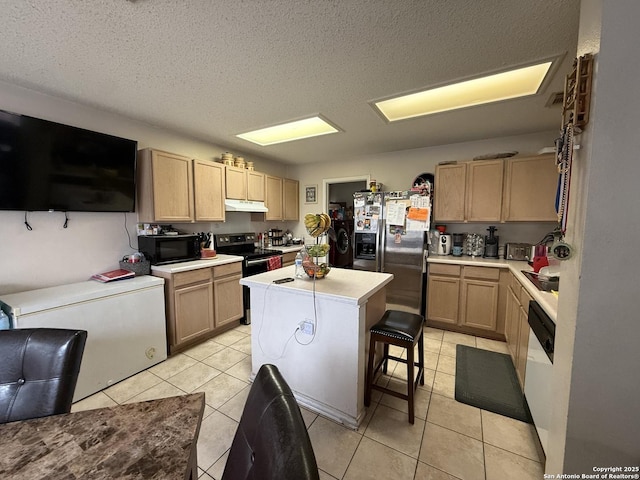 kitchen featuring appliances with stainless steel finishes, a breakfast bar area, a center island, light tile patterned floors, and light brown cabinets