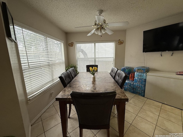 dining room featuring light tile patterned flooring, plenty of natural light, and a textured ceiling