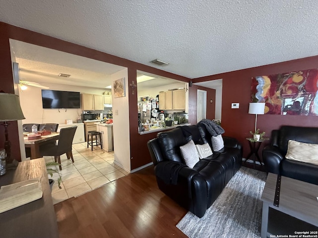 living room featuring light hardwood / wood-style flooring and a textured ceiling