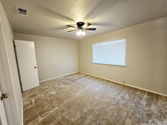 empty room with ceiling fan, carpet floors, and a textured ceiling