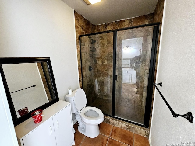 bathroom with tile patterned flooring, toilet, and a shower with shower door