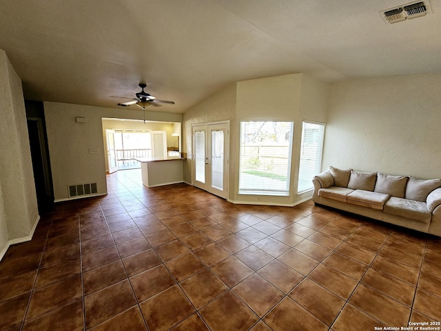 unfurnished living room with dark tile patterned flooring, ceiling fan, and plenty of natural light