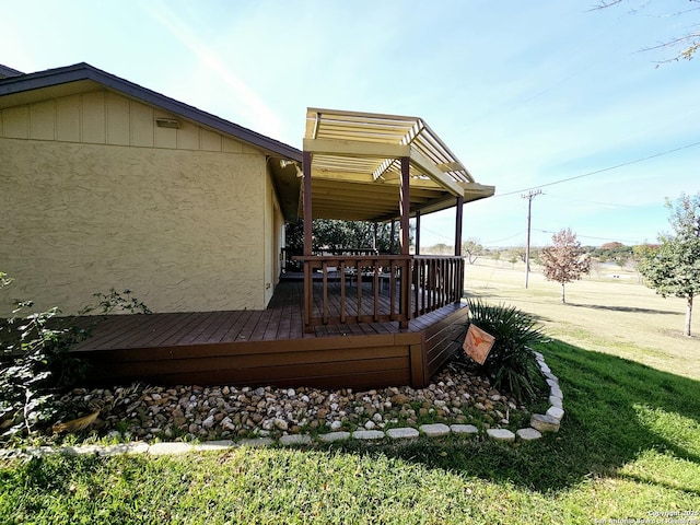 wooden terrace featuring a yard