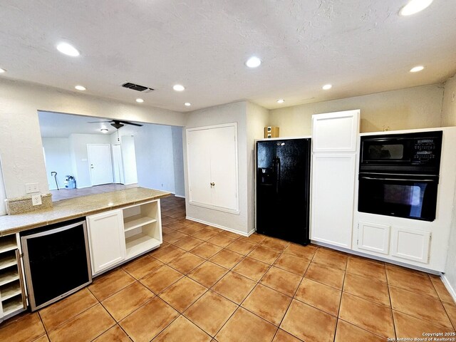 kitchen featuring black appliances, beverage cooler, white cabinetry, and light tile patterned floors