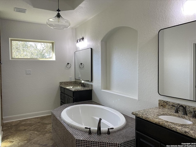 bathroom with vanity and tiled bath