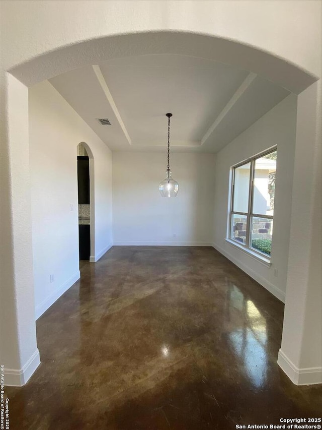 unfurnished dining area featuring a raised ceiling