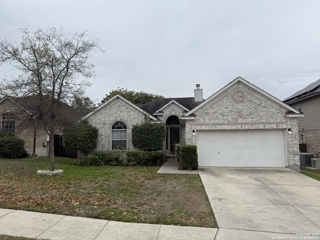 view of front of property with a front yard, a garage, and central air condition unit