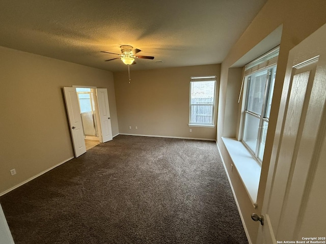 spare room with a textured ceiling, carpet floors, and ceiling fan