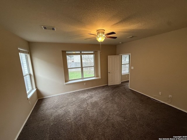 carpeted spare room featuring ceiling fan and a textured ceiling