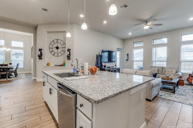 kitchen featuring stainless steel dishwasher, ceiling fan with notable chandelier, sink, pendant lighting, and white cabinetry