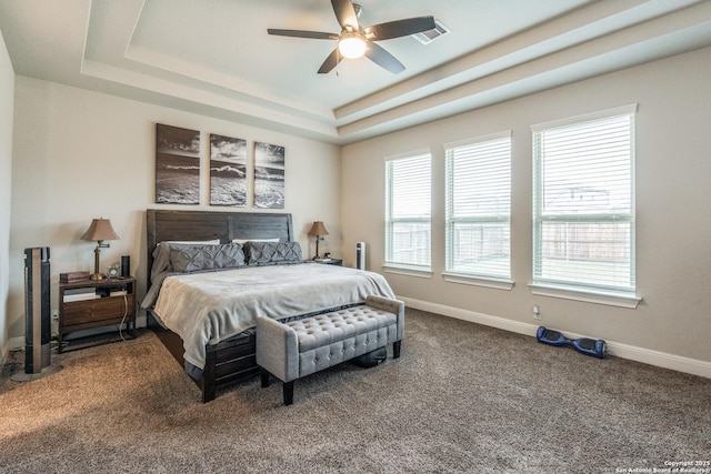 bedroom featuring carpet, a raised ceiling, and ceiling fan