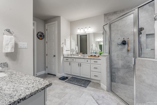 bathroom featuring tile patterned flooring, vanity, and walk in shower