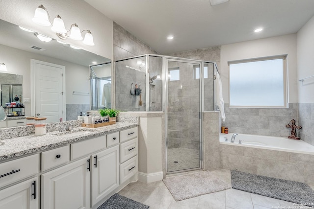 bathroom featuring shower with separate bathtub, vanity, and tile patterned floors