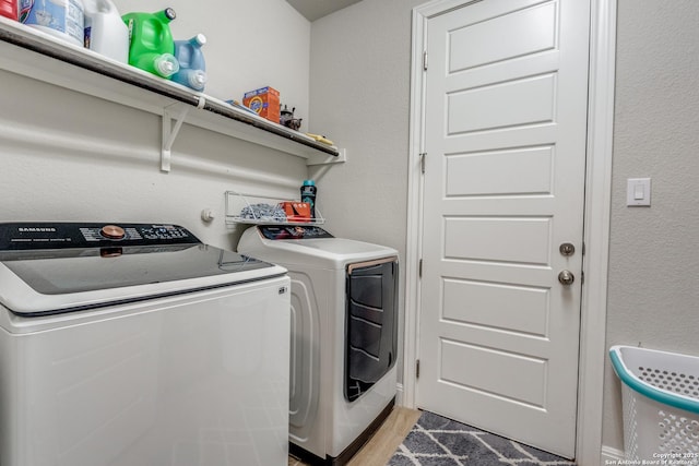 laundry area with light hardwood / wood-style floors and separate washer and dryer