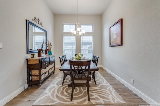 dining room with hardwood / wood-style flooring and a notable chandelier