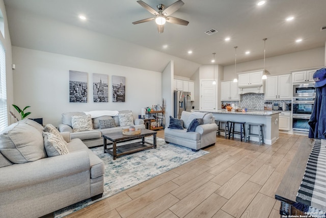 living room with ceiling fan and vaulted ceiling