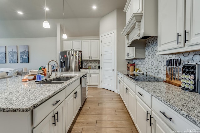 kitchen with a center island with sink, white cabinetry, sink, and appliances with stainless steel finishes