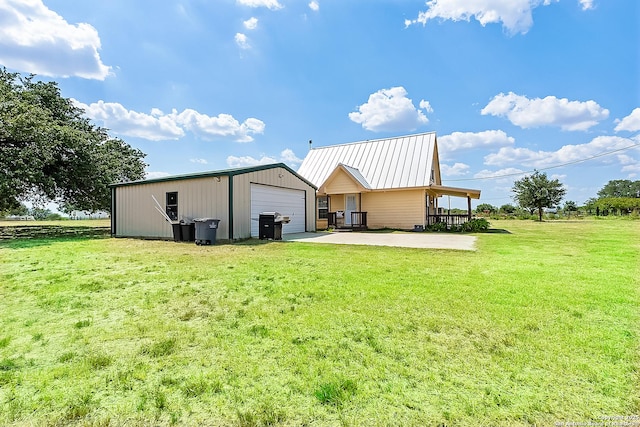 rear view of property with an outbuilding, a yard, and a garage