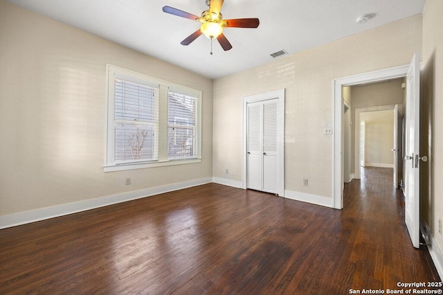 unfurnished bedroom featuring a closet, dark hardwood / wood-style floors, and ceiling fan