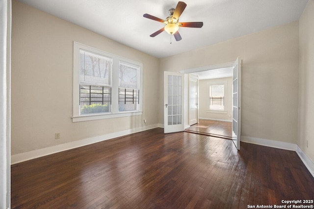 spare room with french doors, ceiling fan, a healthy amount of sunlight, and dark wood-type flooring