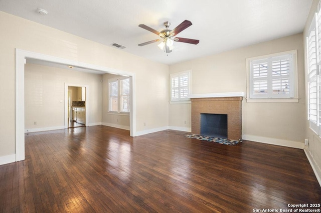 unfurnished living room with a healthy amount of sunlight, dark wood-type flooring, and ceiling fan