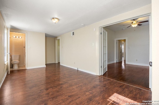 empty room with ceiling fan and dark hardwood / wood-style flooring