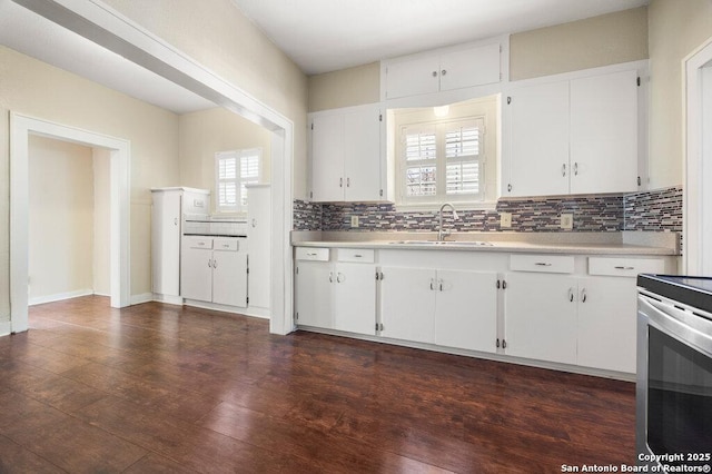 kitchen featuring electric stove, sink, dark hardwood / wood-style floors, tasteful backsplash, and white cabinets