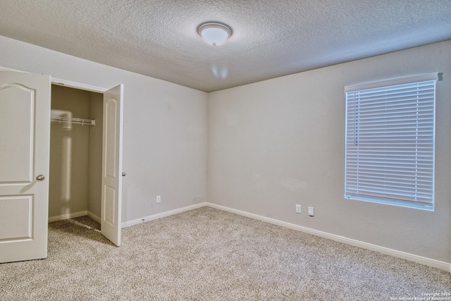 unfurnished bedroom with a textured ceiling, light colored carpet, and a closet