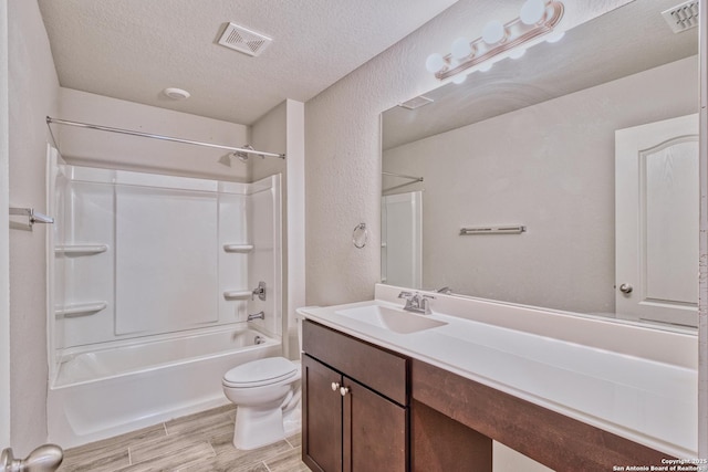 full bathroom featuring shower / washtub combination, vanity, a textured ceiling, and toilet