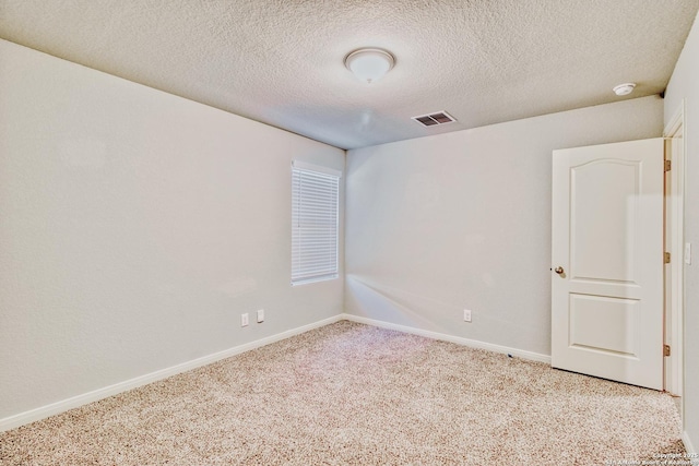 carpeted empty room with a textured ceiling