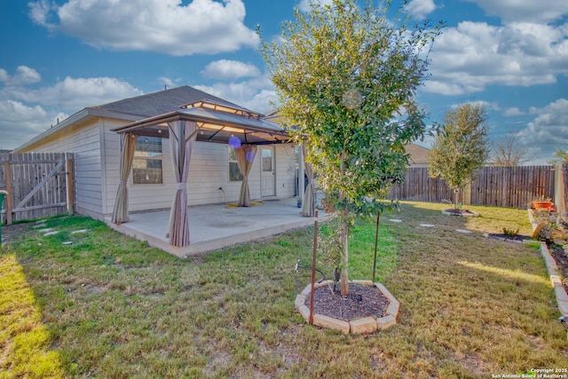 back of house featuring a gazebo, a yard, and a patio