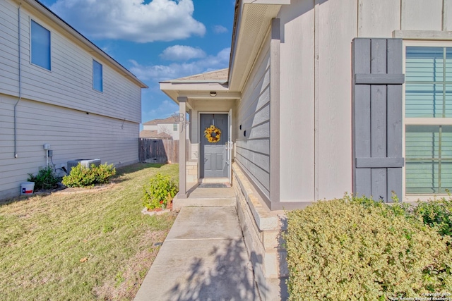 entrance to property with central air condition unit and a yard