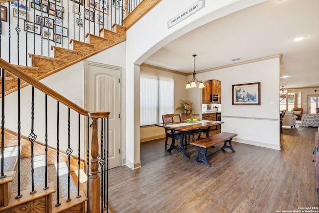 interior space featuring a notable chandelier, ornamental molding, and dark wood-type flooring