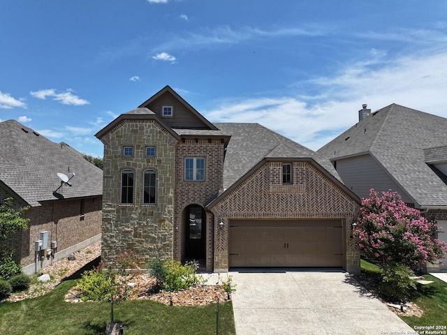 view of front of property featuring a garage and a front lawn