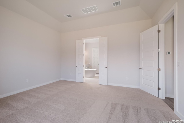 carpeted spare room with lofted ceiling