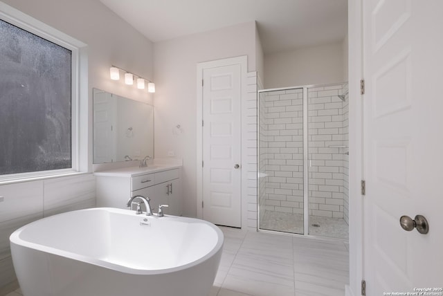 bathroom with tile patterned floors, vanity, tile walls, and shower with separate bathtub