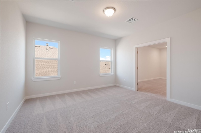 unfurnished room featuring a healthy amount of sunlight and light colored carpet