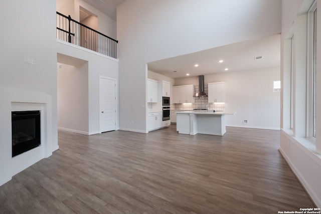 unfurnished living room with dark wood-type flooring and a high ceiling