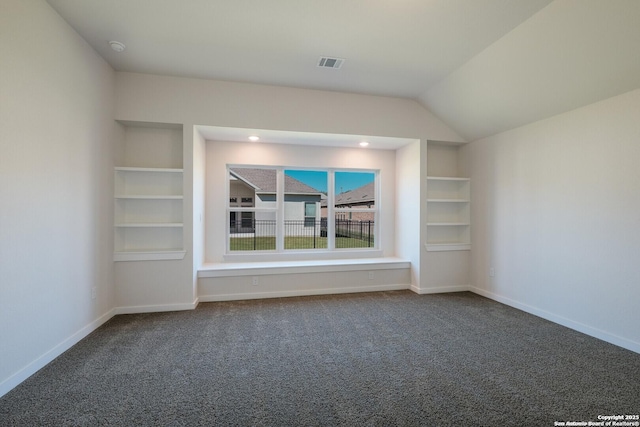 interior space with carpet flooring, built in shelves, and vaulted ceiling