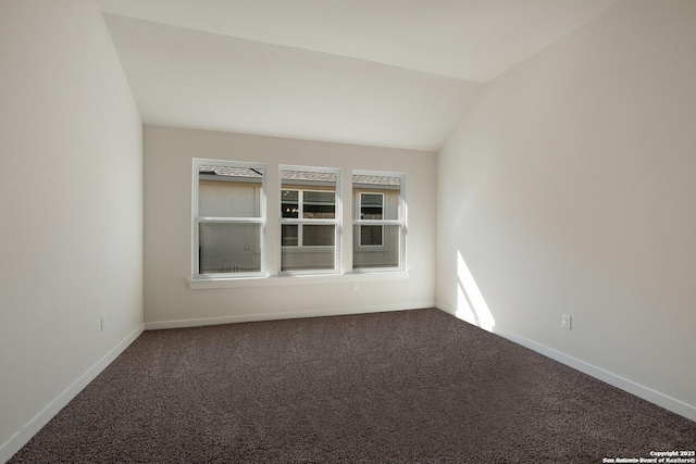 empty room with carpet and vaulted ceiling