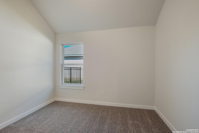 carpeted empty room with lofted ceiling