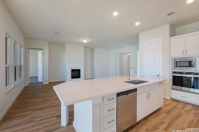 kitchen featuring white cabinetry, sink, an island with sink, and stainless steel appliances