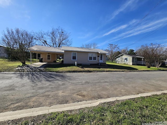 single story home featuring a front lawn and a carport