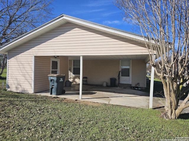 back of property with a carport and a lawn