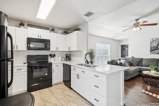 kitchen featuring white cabinetry, sink, and black appliances