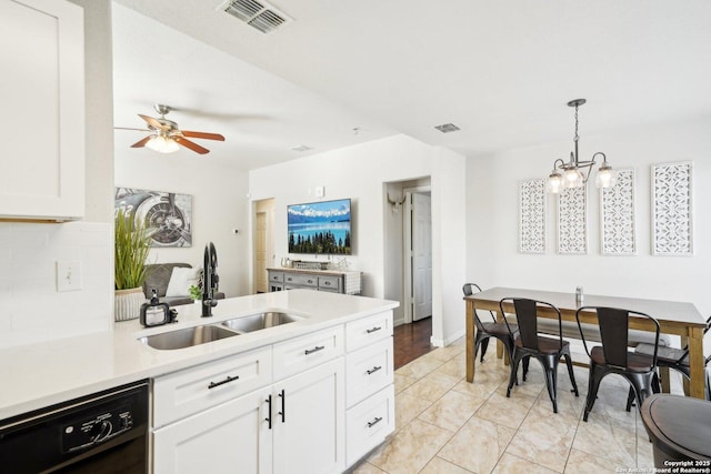 kitchen featuring pendant lighting, dishwasher, white cabinets, ceiling fan with notable chandelier, and sink