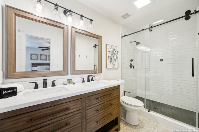 bathroom with vanity, toilet, a shower with door, and ceiling fan