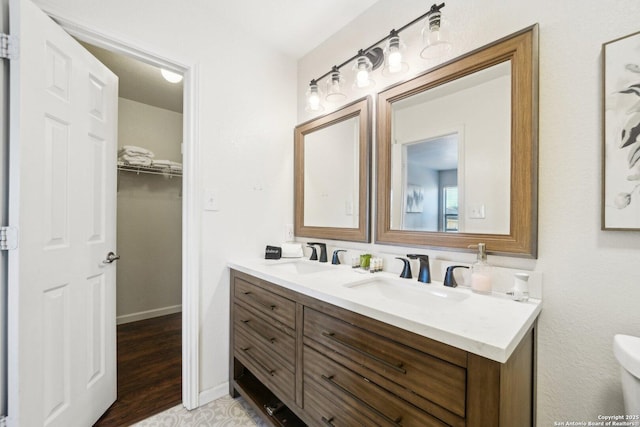 bathroom with toilet, vanity, and hardwood / wood-style flooring