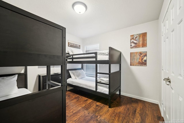 bedroom with dark hardwood / wood-style flooring and a textured ceiling